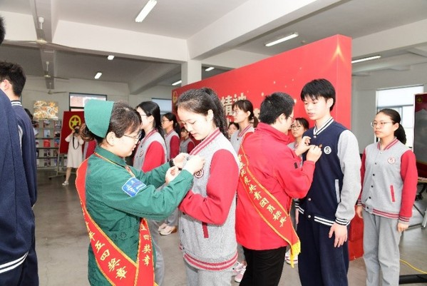 学校优秀毕业生代表、援鄂医疗队队员为团员代表佩戴团徽
